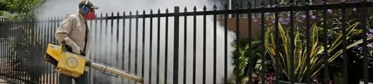 Mosquito control technician fogging a yard perimeter for mosquito reduction in Boston, MA